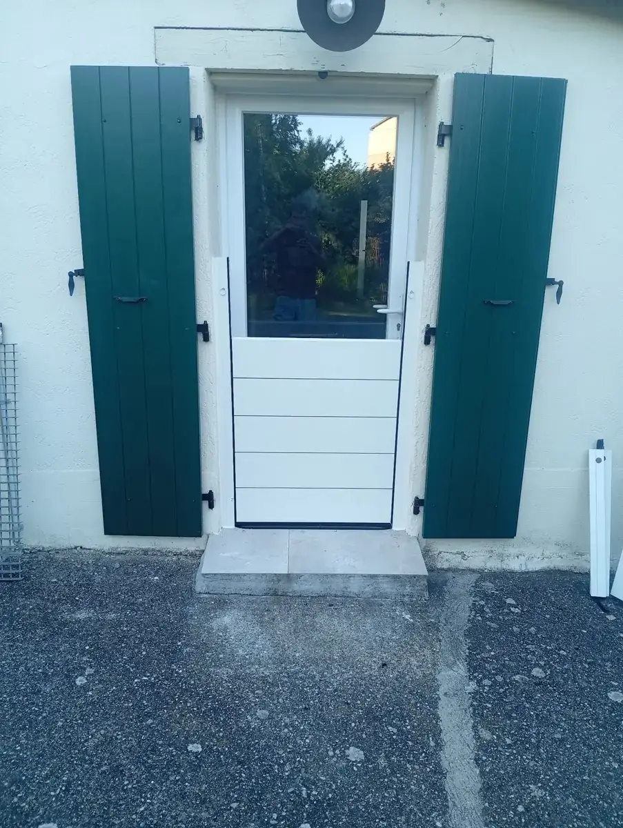 Puerta de entrada con contraventanas verdes y una barrera de lamas a su medida