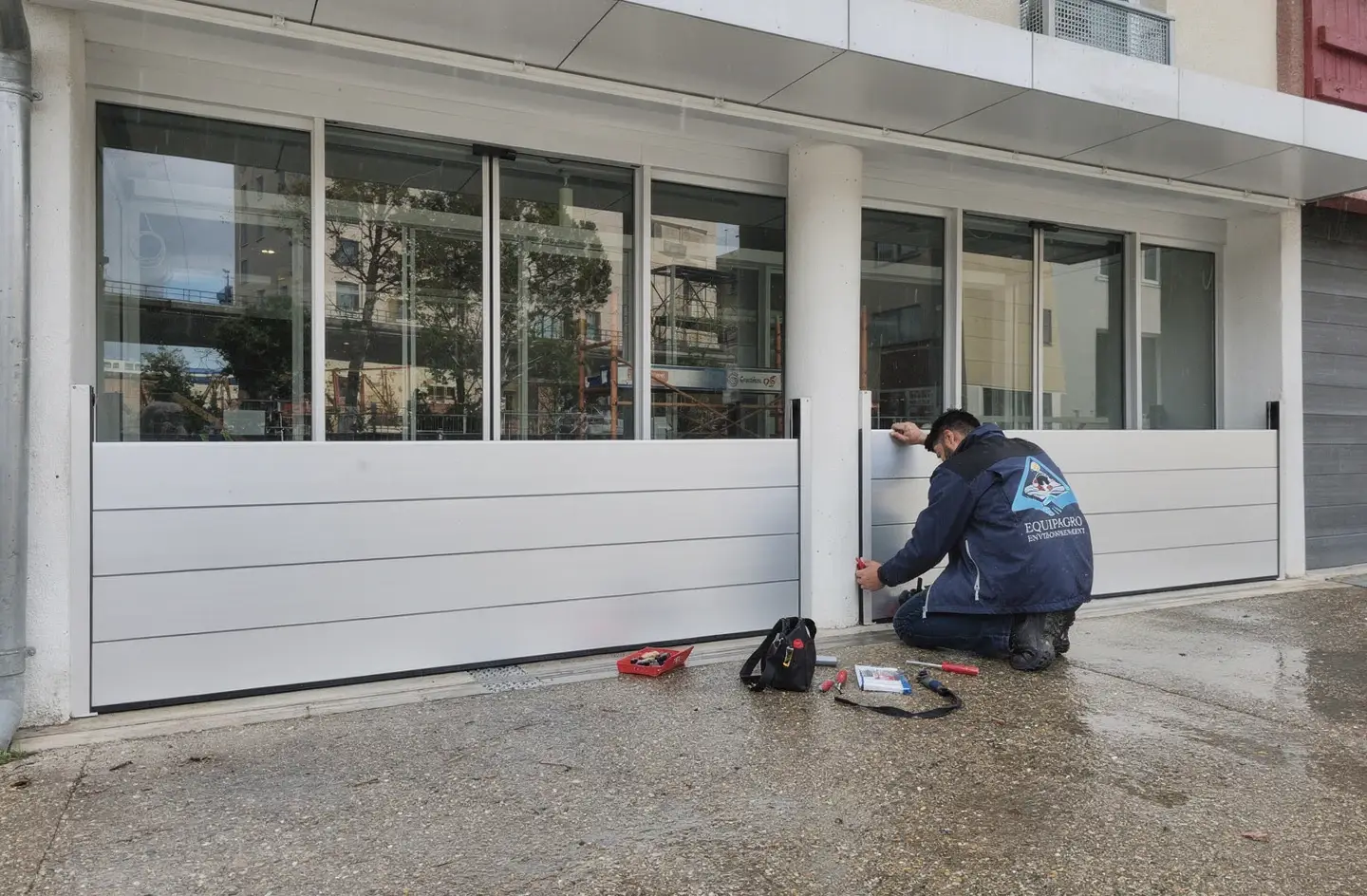 Técnico de Equipagro colocando una barrera antiinundación apilable delante de un escaparate